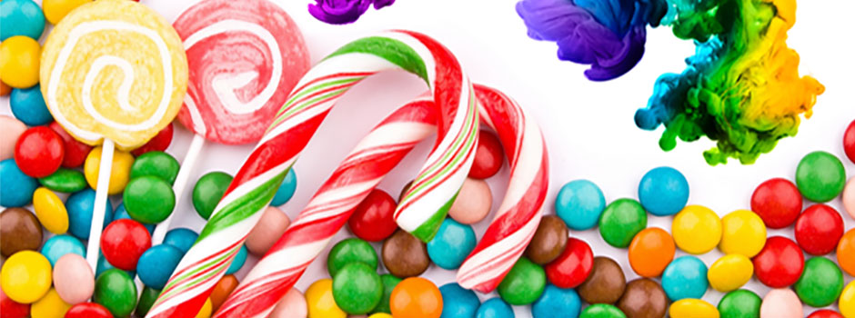 Brightly coloured sweets, candy canes and lollipops beside swirls of dye, from SANUSq Health on artificial food dyes