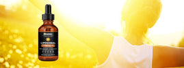 SANUSq Health liposomal Vitamin D3 + K2 drops beside a woman with open arms in golden sunlight, supporting natural immunity