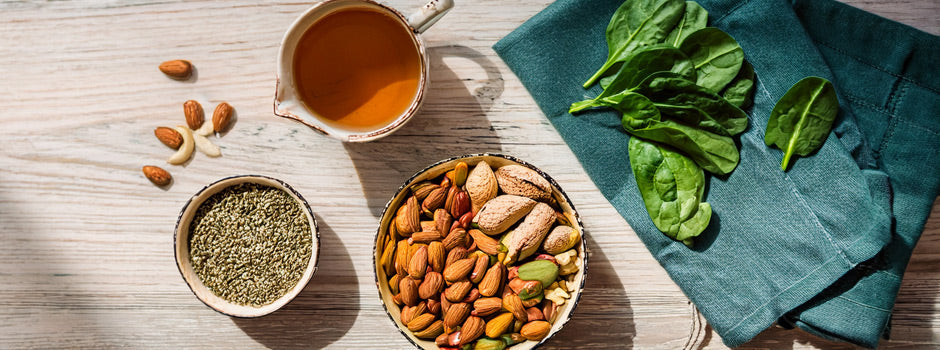 Magnesium-rich foods — pumpkin seeds, almonds, spinach and dark chocolate — on a table in soft autumn morning light