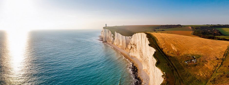 White chalk cliffs in golden sunlight above a calm sea, a symbol of vitamin D3, K2 and calcium